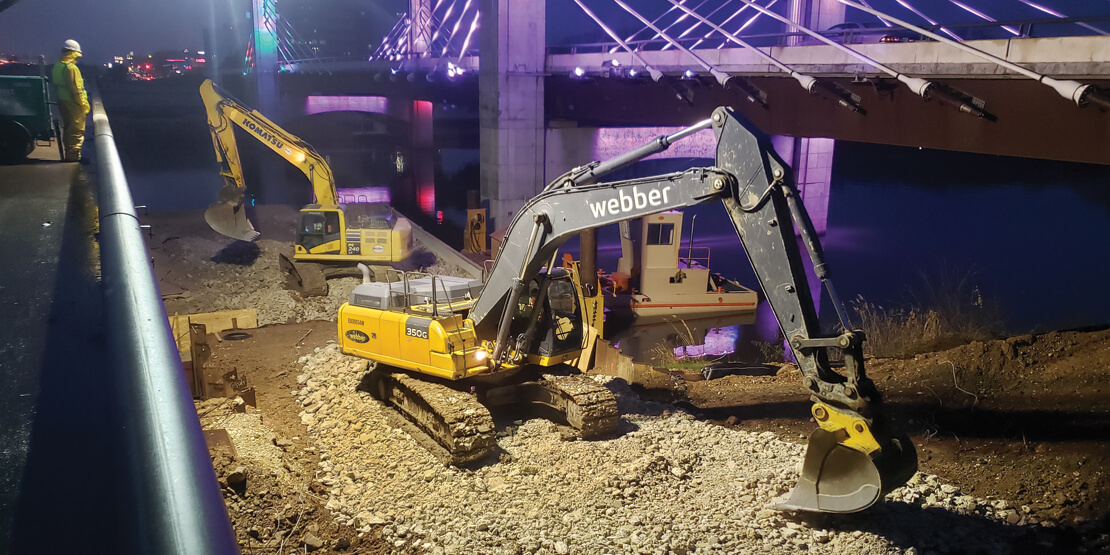 Two cranes moving concrete away from the old IH 35 Waco 4B freeway at night