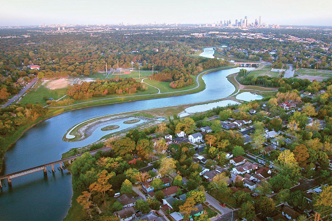 An aerial view of beautiful greenery with a river cutting through a suburb