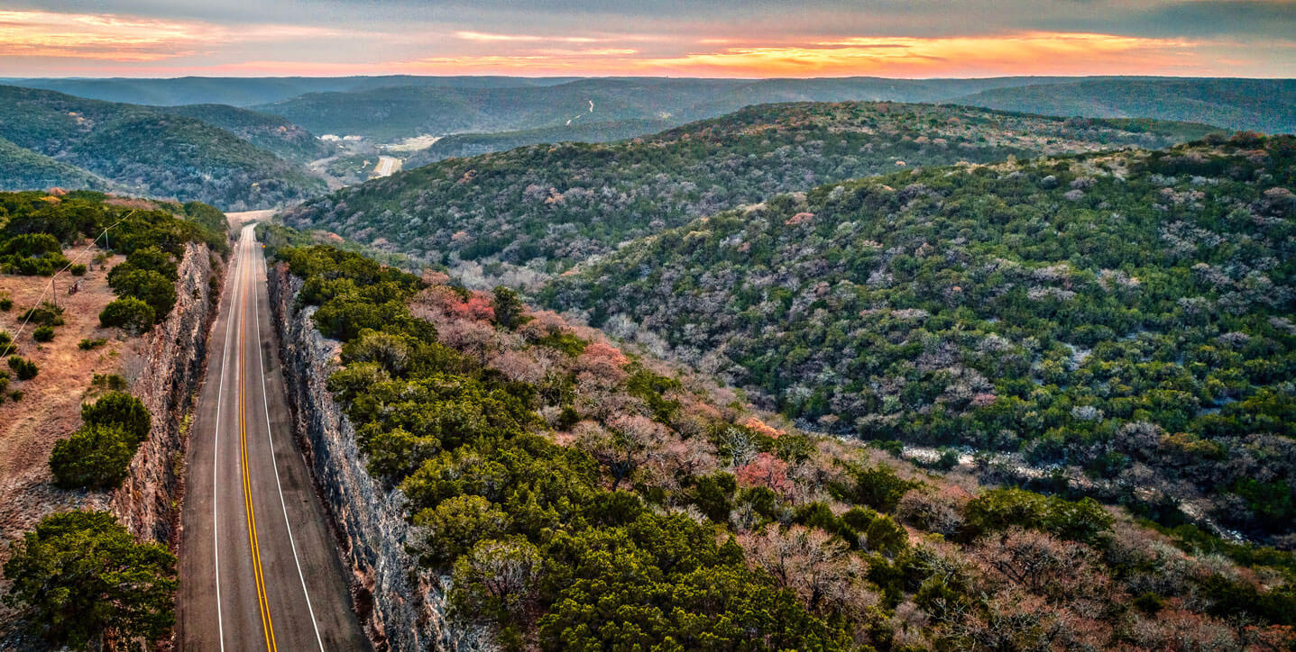 A scenic view of rolling hills in Texas at sunset