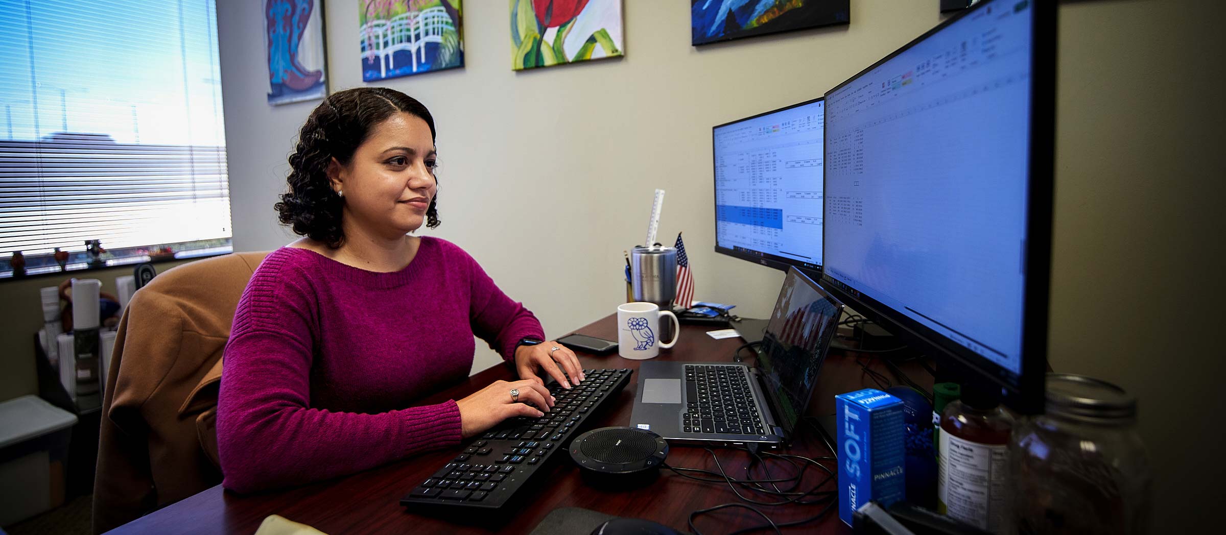 A BGE employee working at her computer with her dual monitors