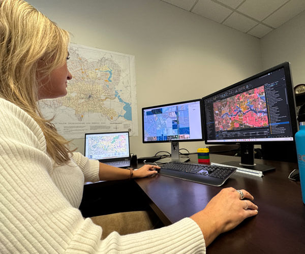 A BGE employee working on infrastructure plans on her computer